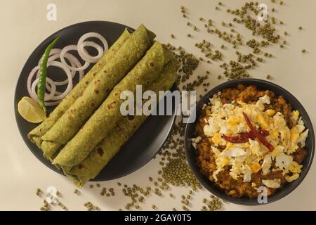 Indisches Fladenbrot aus Vollkornmehl, das mit pürierten Spinat und Gewürzen geknetet wurde. Serviert mit Sauce aus grünen Moong-Bohnen und Rührei darauf. Po Stockfoto