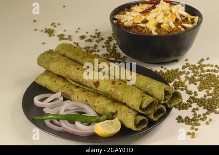 Indisches Fladenbrot aus Vollkornmehl, das mit pürierten Spinat und Gewürzen geknetet wurde. Serviert mit Sauce aus grünen Moong-Bohnen und Rührei darauf. Po Stockfoto