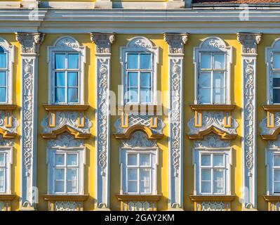 Fassade oder Vorderansicht eines schönen alten Gebäudes in timisoara, Rumänien. Architektonisches Detail von zwei gelben Holz gerahmten Fenstern Stockfoto