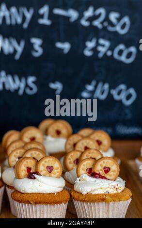 Kuchen im Verkauf, Süßwaren, Kuchen in der Bäckerei, leckere Kuchen auf der Ausstellung, kleine Cupcakes im Verkauf, süße Kuchen auf einem Tablett in einem Bäckerladen, Backen. Stockfoto