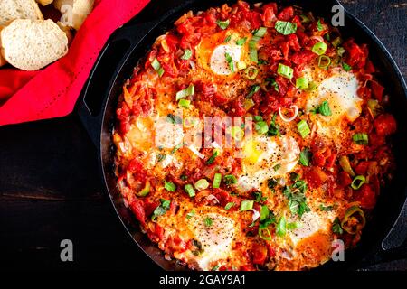 Türkische Menemen in einer gusseisernen Pfanne serviert: Türkisches Ei und Tomate Frühstück in einer gusseisernen Pfanne serviert Stockfoto