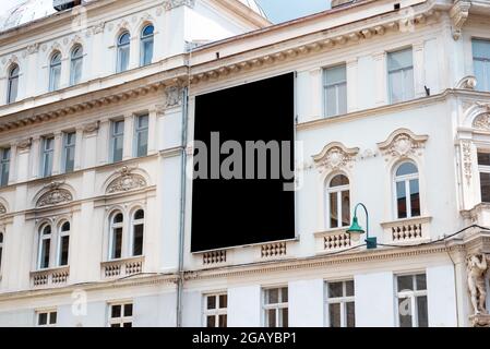 Leere schwarze Plakatwand für Nachbau an der Fassade eines alten Stadtgebäudes Stockfoto