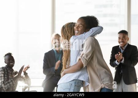 Glückliche junge afrikanische Ethnie Frau kuscheligen Kollegen. Stockfoto