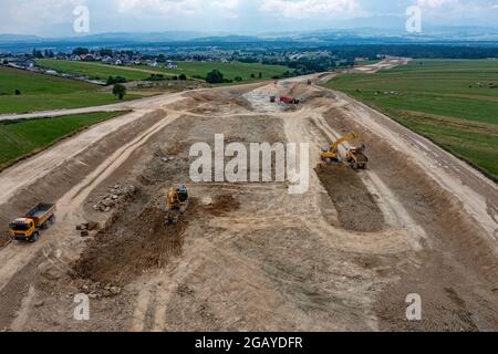 Luftaufnahme des Baggers, der den Kipper auf der Baustelle beladen hat. Stockfoto