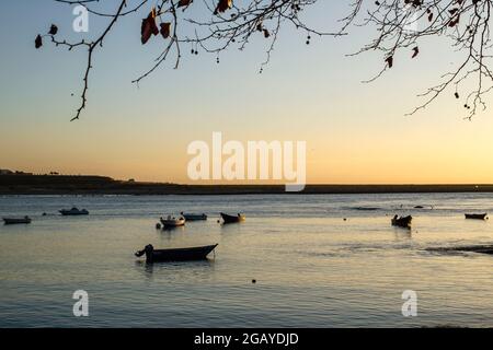 Kleine Boote, die bei Sonnenuntergang am Kai festgebunden sind Stockfoto