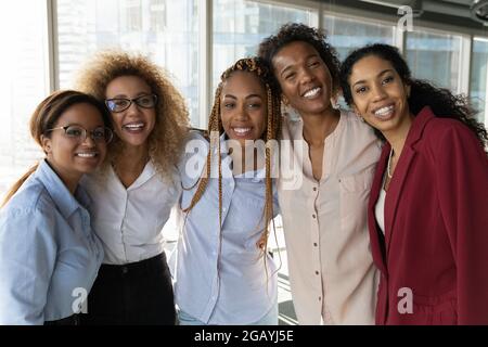 Glückliche Millennial verschiedene biracial weibliche Mitarbeiter Blick auf die Kamera. Stockfoto