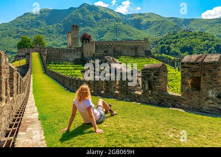 Frau auf der Spitze von Bellinzona, der historischen Stadt in der Schweiz. Mauern des Schlosses Montebello in Bellinzona, Hauptstadt des Kantons Tessin Stockfoto