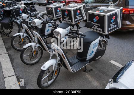 Vieanna, Österreich - 10. Oktober 2019: Blick auf Domino Pizza, eine amerikanische multinationale Pizza-Restaurantkette, Lieferung Roller Fahrzeug auf der Straße i Stockfoto