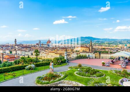 Blick auf Florenz von der Piazzale Michelangelo, mit Kathedrale im Hintergrund. Blauer Himmel und ein Paar zu Fuß. Toskana Region, Italien. Stockfoto