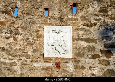 Wappen der Familie Appiani am Eingang der mittelalterlichen Stadt Populonia, Gemeinde Piombino, Toskana, Italien. Stockfoto