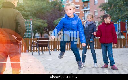 Kinder springen auf chinesischem Springseil Stockfoto