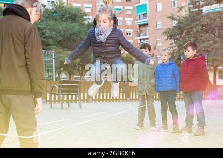 Kinder Überspringen auf chinesische Springen elastische Kordel im Hof Stockfoto