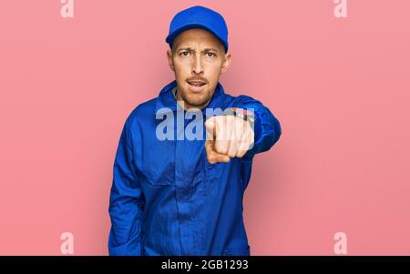 Kahlköpfiger Mann mit Bart, der einen Overall trägt, zeigt unzufrieden und frustriert auf die Kamera, wütend und wütend auf dich Stockfoto