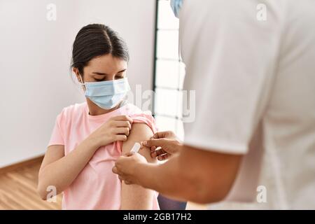 Junge Krankenschwester Mann legte Band Hilfe auf Frau Arm in der Klinik. Stockfoto