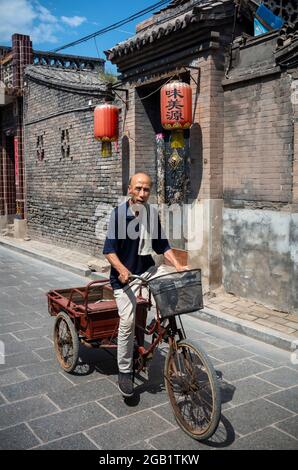 Pingyao, China. Juli 2021. Ein Mann fährt mit seinem Fahrrad die Straße entlang in der Altstadt von Pingyao, China am 31/07/2021 Acient City und die Stadtmauern sind das UNESCO-Weltkulturerbe von Wiktor Dabkowski Credit: dpa/Alamy Live News Stockfoto