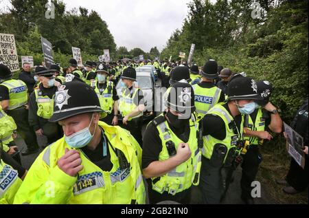 Polizeibeamte eskortieren die Fabrikarbeiter und ihre drei Autos, während Demonstranten während der Demonstration die Straße blockieren. Demonstranten aus dem ganzen Land schlossen sich Camp Beagle an, um Unterstützung zu bieten und sich an Tausende von Welpen zu erinnern, die in den letzten 50 Jahren auf MBR Acres produziert wurden. Die Aktivisten werden vor der Fabrik campen, bis sie geschlossen und alle Beagle frei sind. Camp Beagle ist ein Protestcamp am Straßenrand, das vor vier Wochen außerhalb von Beagle-Züchtern Marshal Bioresources (MBR) Acres eingerichtet wurde. Ihre Welpen werden in Tierversuchslabors verkauft. Nachdem Sie sich alarmierende Videos von Be angesehen haben Stockfoto