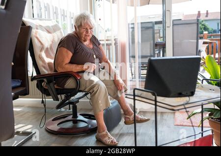 22. Juli 2021, Rheinland-Pfalz, Zweibrücken: Die 80-jährige Gerlinde Mauß sagt Alexa, sie soll Musik machen. Im Rahmen des Projekts 'IXEM deheem' haben Senioren eine Sprachsteuerungsassistentin Alexa erhalten. (To dpa 'Du fühlst dich nicht mehr so allein': Technologie gegen Einsamkeit im Alter') Foto: Oliver Dietze/dpa Stockfoto