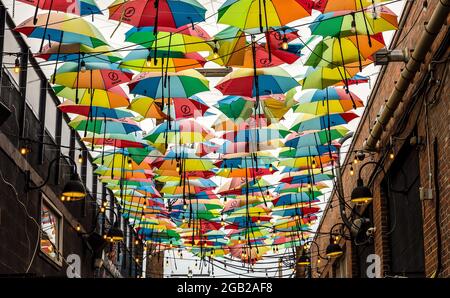 Denver, Colorado - 31. Juli 2021: Bunte Regenschirme Straßendekoration in der engen Gasse des Rino-Kunstviertels in Denver, Colorado Stockfoto
