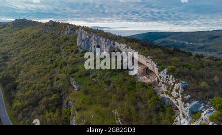 Luftdrohnenansicht von Veli Badin, natürliche Steinklippe in den Felsen geschnitzt, der den Boden überlappt, während eines sonnigen Nachmittags. Majestätische Felsstruktur in s Stockfoto