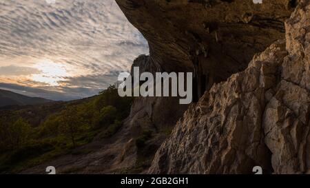 Blick auf Veli Badin, natürliche Steinklippe in den Felsen geschnitzt überlappen den Boden, an einem sonnigen Nachmittag. Majestätische Felsstruktur im slowenischen Kars Stockfoto