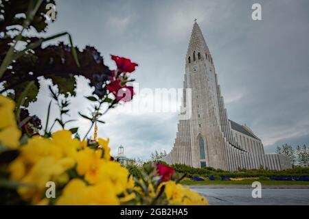 Hallgrimskirkja, eine luteranische Kirche mitten in Reykjavik, der Hauptstadt Islands, von vorne gesehen an einem bewölkten Sommertag. Stockfoto