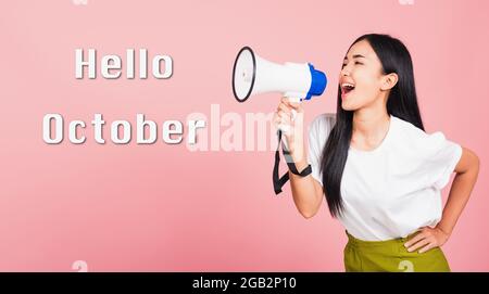 Hallo Oktober, Porträt von glücklichen asiatischen schönen jungen Frau zuversichtlich lächelndes Gesicht halten Ansage Nachricht schreiend in Megaphon Stockfoto