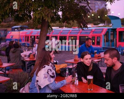 Junge Erwachsene treffen sich in einer Außenbar am Victoria Quay, Sheffield, entlang des Sheffield- und Tinsley-Kanals. Stockfoto