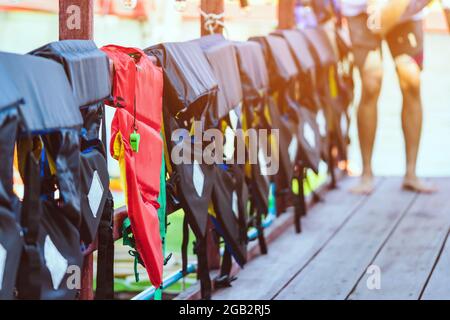 Eine grüne Pfeife mit roter Lebensjacke, die am Geländer um den Gehweg hängt, damit die Passagiere sicher an den Docks sind. Stockfoto