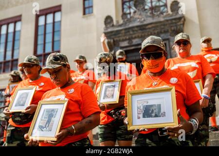 Shawna Brady (links unten), 49, von der Ostseite Kolumbus beugt sich während eines Gebets von Pfarrer Michael Young vor dem Kopf, während sie ein Bild ihres Sohnes Tre-von Dickson auf den Stufen des Columbus City Hall hält. Als Reaktion auf die zunehmende Gewalt seit 2020 Malissa Thomas-St. Clair, eine Mutter eines ermordeten Sohnes, Anthony Thomas-St. Clair, Gründer von Mothers of Murdered Columbus Children (MOMCC), einer Anti-Gewalt-Gruppe, die in Columbus, Ohio, Gewaltverbrechen beenden will. MOMCC leitete die Bemühungen für einen Anti-Gewalt-Marsch in Zentral-Ohio und eine Kundgebung im Rathaus mit vielen anderen Müttern, die Kinder durch Gewalt verloren haben, Stockfoto