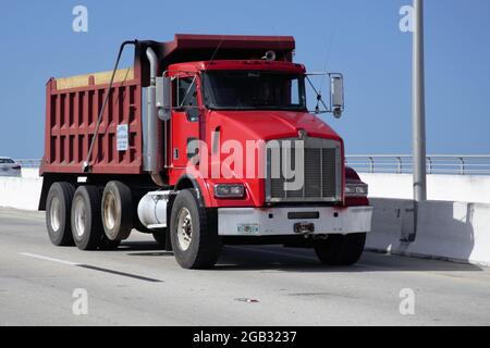 Roter Kenworth Dreiachs-Muldenkipper auf einer Autobahn in den USA Stockfoto
