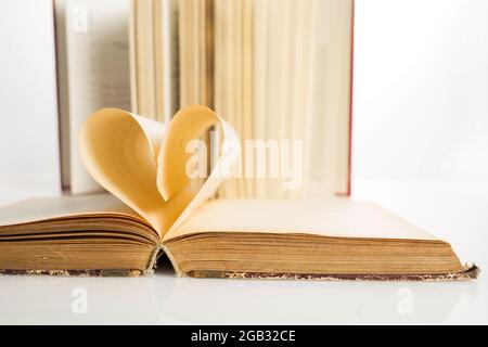National Book Lovers Day. August 9. Das Buch öffnet sich, und die Buchseite rollt ins Herz Stockfoto