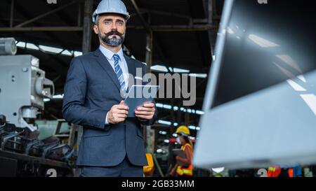 Engineering Engine Machine Controller Manager Control Manager Control Concept, intelligente technische Ingenieur in Anzug hält Tablet-Kontrolle, arbeiten in i Stockfoto