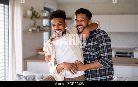 Junge Erwachsene Brüder in der Küche drinnen zu Hause, Spaß haben. Stockfoto