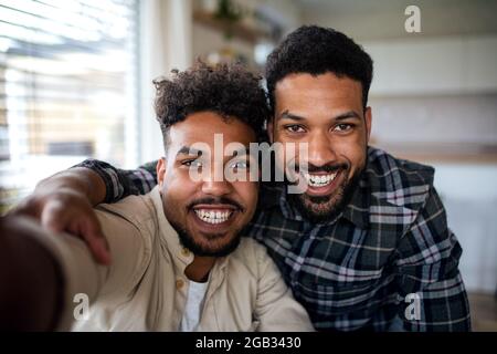 Porträt von jungen erwachsenen Brüdern in der Küche drinnen zu Hause, Selfie zu nehmen. Stockfoto