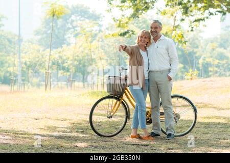 Alte Liebe Paar Wandern mit dem Fahrrad und reden im Park, Senior Romantiker Konzept Stockfoto