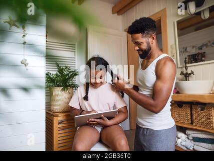 Glücklicher junger Mann mit kleiner Schwester zuhause, Spaß im Badezimmer. Stockfoto