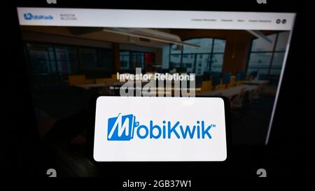 Person, die das Smartphone mit dem Logo des indischen Finanztechnologieunternehmens MobiKwik auf dem Bildschirm vor der Website hält. Konzentrieren Sie sich auf die Telefonanzeige. Stockfoto