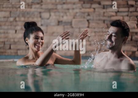 Portrait von glücklichen jungen Paar in der Liebe im Schwimmbad, Spaß haben. Stockfoto