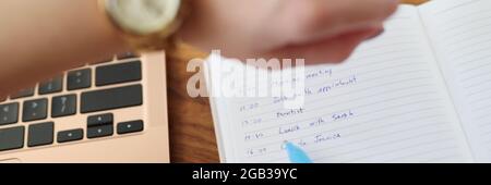 Frau zeigt mit Stift, um Liste für heute und zu tun Blick auf die Uhr aus der Nähe Stockfoto