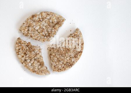 Gebrochene gepuffte Reiskuchen auf weißem Hintergrund isoliert, zerkleinerte Diät knusprige runde Reiswaffeln Stockfoto