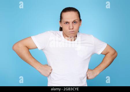 Junger Mann runzelte isoliert auf blauem Hintergrund die Stirn. Stockfoto