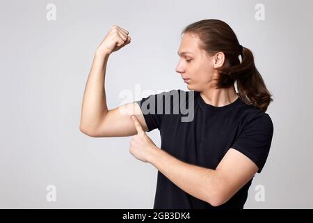 Junge Fitness starker Mann zeigen Bizepsmuskeln auf der Hand Stockfoto