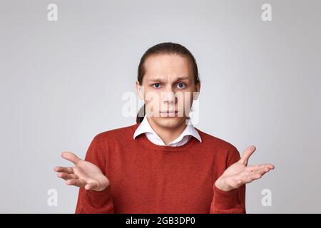 Junger, hübscher Mann mit einem Zweifel im Gesicht im Hemd Stockfoto