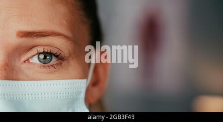 Kaukasische blonde blauäugige Krankenschwester trägt OP-Maske Stockfoto