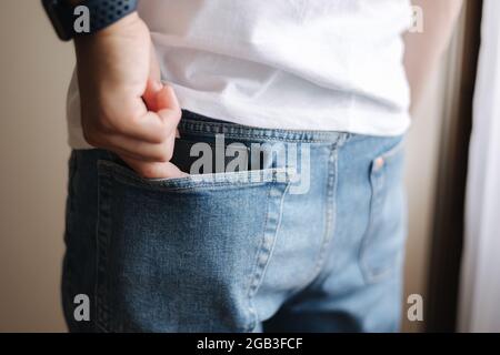 Rückansicht des Mannes, der die Brieftasche aus der Gesäßtasche nimmt Stockfoto