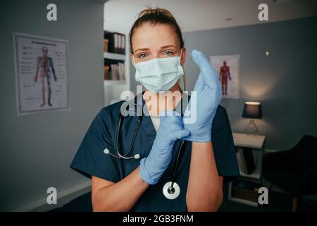 Kaukasische Krankenschwester, die in der Arztpraxis mit chirurgischer Ausrüstung steht Stockfoto