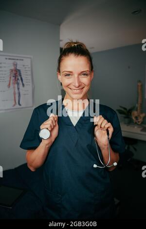 kaukasische Krankenschwester, die in der Arztpraxis mit Stethoskop steht Stockfoto