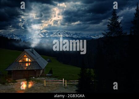 highlander Hütte mit Rauch aus dem Kamin vor der Kulisse eines Bergpanoramas in der Tatra Stockfoto