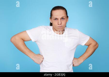 Junger Mann runzelte isoliert auf blauem Hintergrund die Stirn. Stockfoto