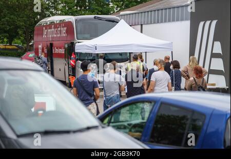 Mainz, Deutschland. August 2021. Vor dem Impfbus vor einem Aldi-Laden im Landkreis Hechtsheim warten die Menschen ohne vorherige Registrierung auf die Corona-Impfung in der Schlange. Nach den Angeboten in den Impfzentren des Landes und bei Ärzten in der Privatpraxis sind nun sechs Impfbusse in allen Teilen von Rheinland-Pfalz unterwegs und ermöglichen Corona-Impfungen ohne Registrierung. Insgesamt sollen sie bis Ende August 2021 an mehr als 200 Stationen anhalten. Kredit: Frank Rumpenhorst/dpa/Alamy Live Nachrichten Stockfoto